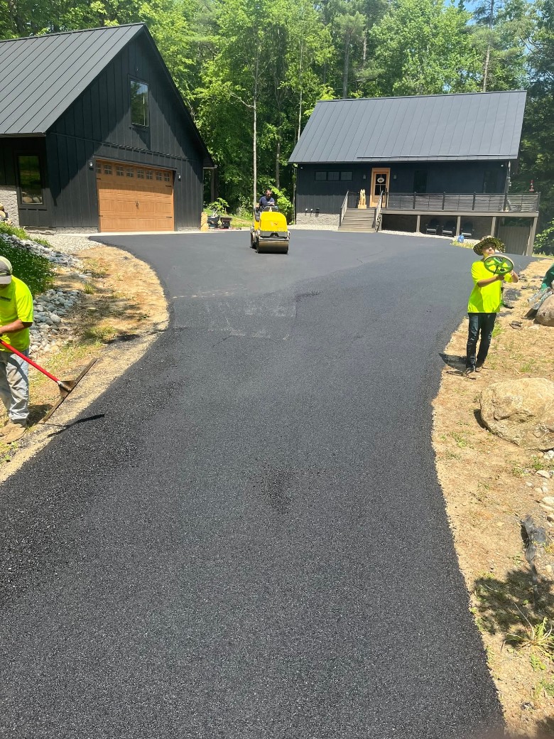 two workers next to a newly paved driveway