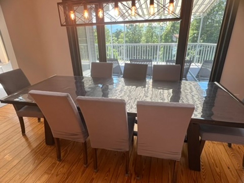 a dining room table with chairs and lights above