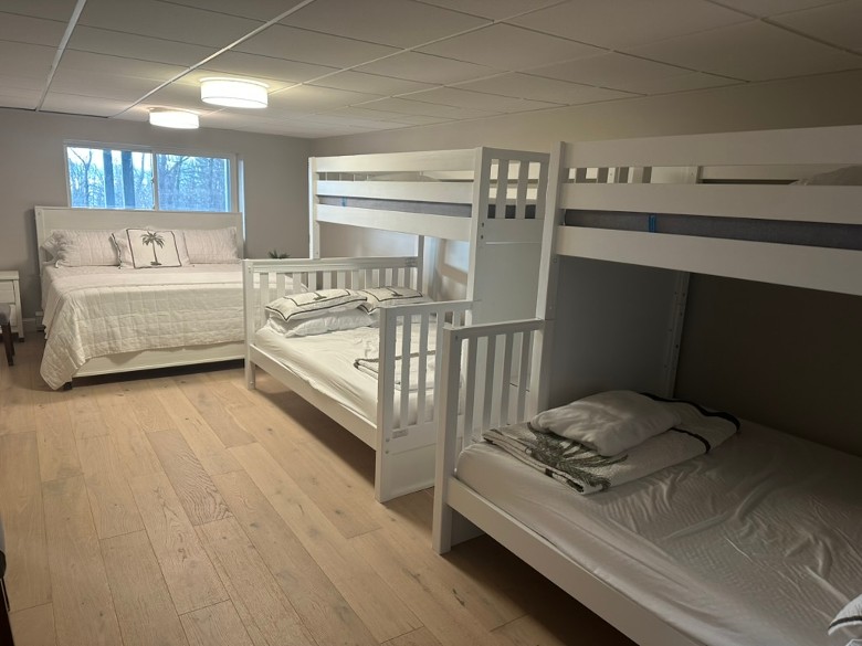 a bedroom with two bunk beds, and another single bed in the back