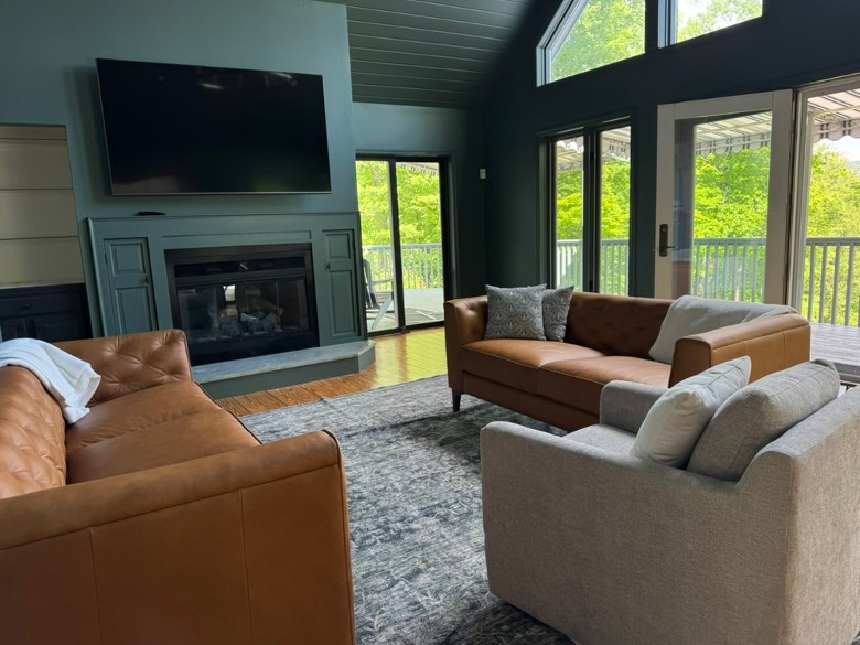 a living room with couches, a fireplace, and a TV above the fireplace