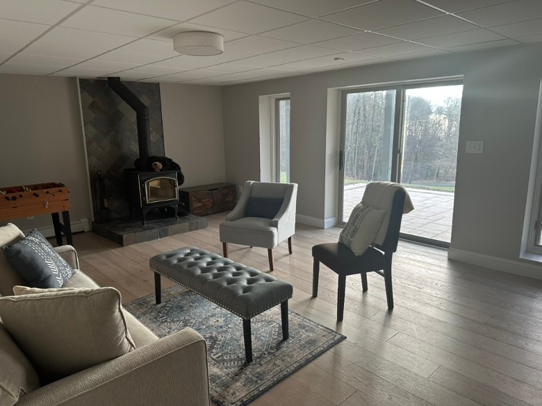 a lounge with a fireplace, chairs, a couch, and a foosball table