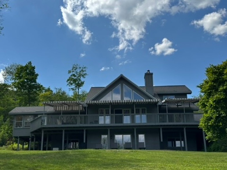 exterior of a multi story dark gray house with blue sky above