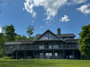 exterior of a multi story dark gray house with blue sky above