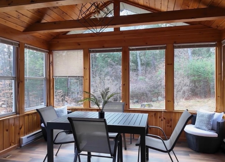 a sunroom with a table and chairs