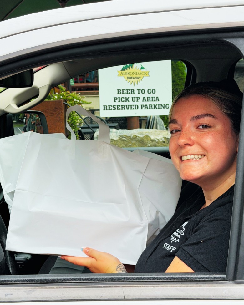 a woman holding a takeout bag in a car