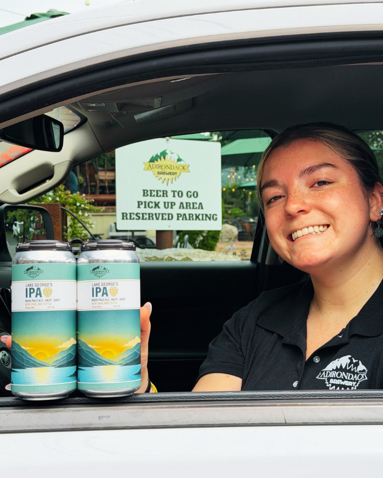 a woman holding cans of IPA in a car