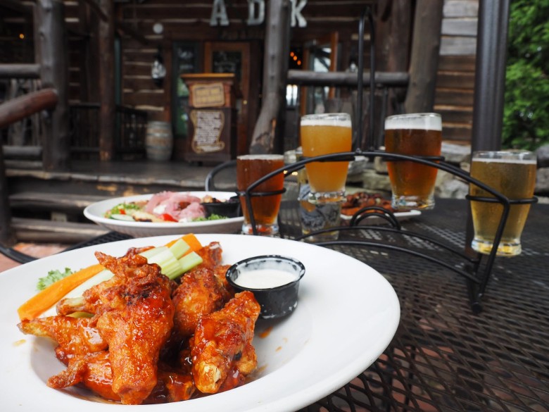 chicken wings and a beer stand with four beers