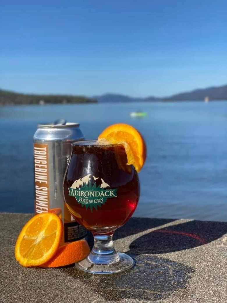 can of beer and a beer glass by the lake