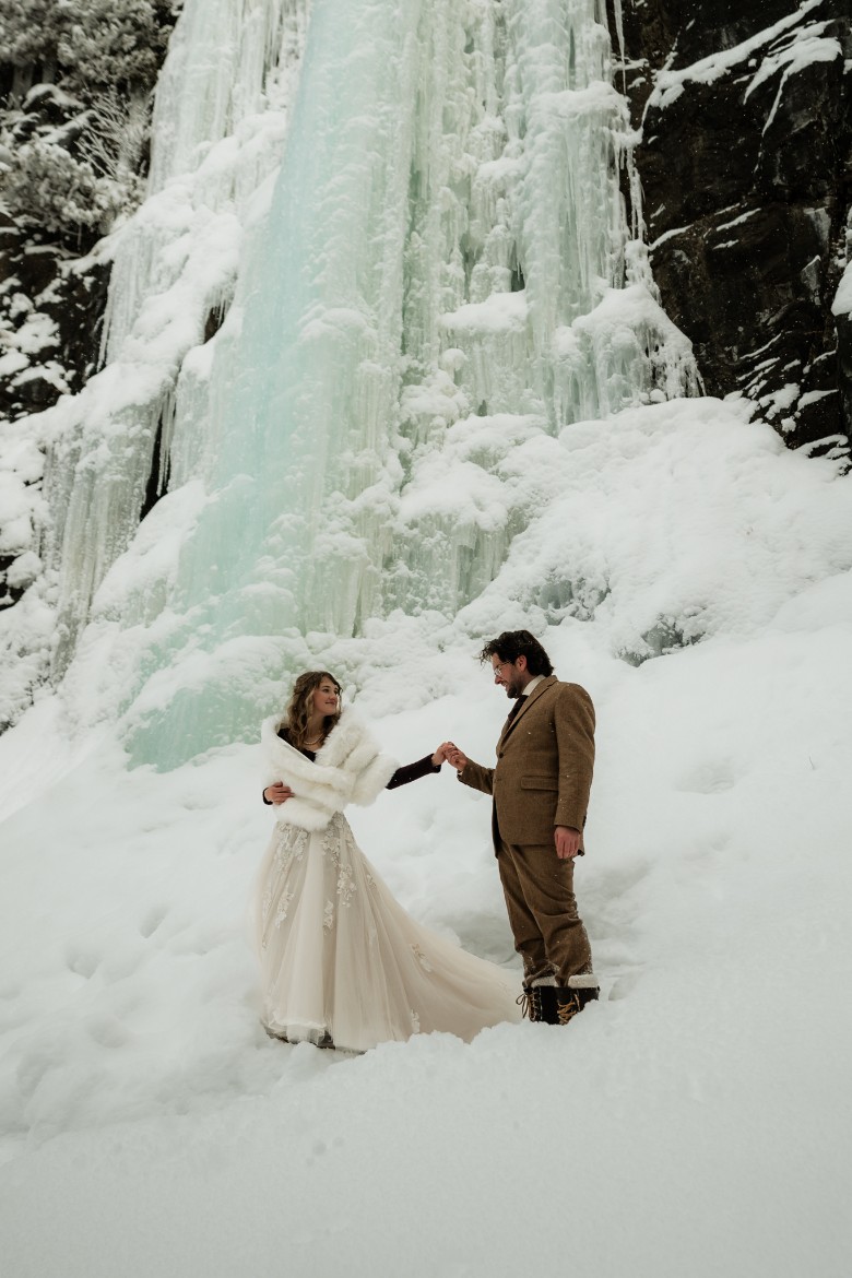 couple in front of frozen waterfall