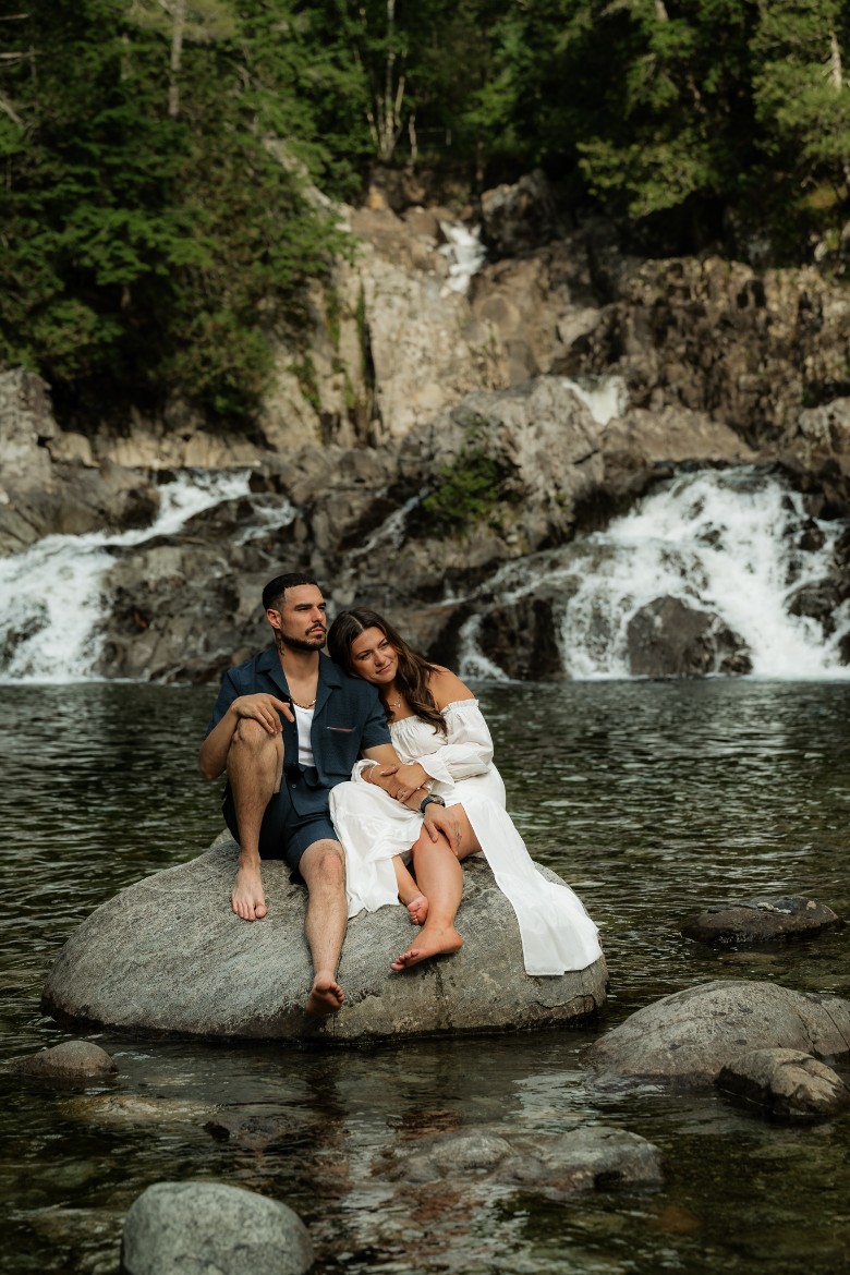 couple on a rock with waterfall in the background
