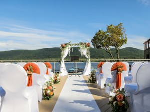 an outdoor wedding ceremony set up by the lake