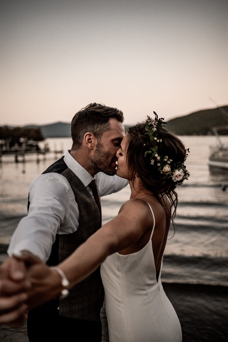 bride and groom kissing by the waterfront