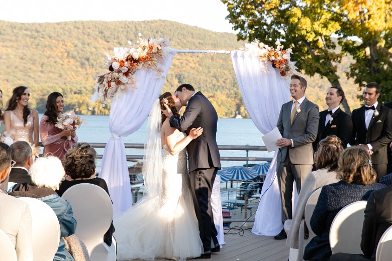 bride and groom kissing during an outdoor wedding ceremony
