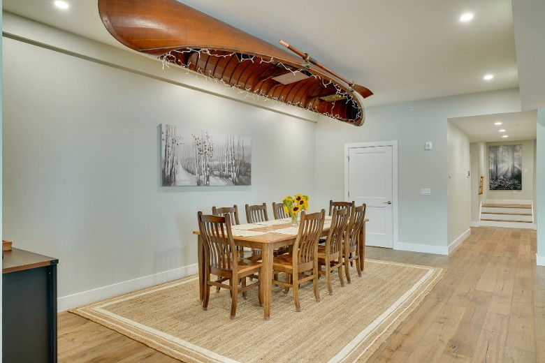 dining room table with a canoe hanging from the ceiling above it