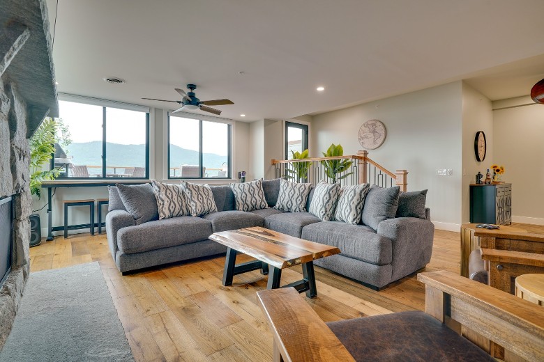 a living room in a house, with wooden floors, and a grey couch