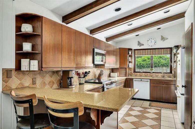 modern kitchen in a house with chairs at the breakfast counter