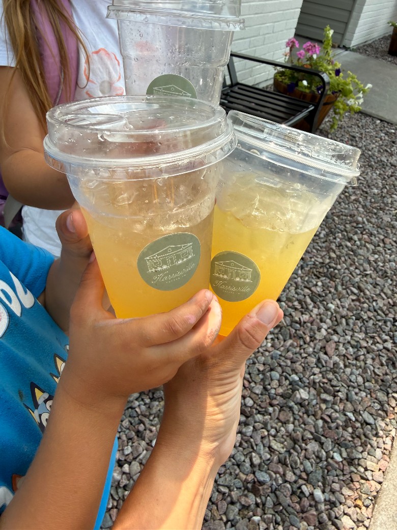 Citrus-hued beverages held up outside Harrisville Coffee Co. two iced lemonades