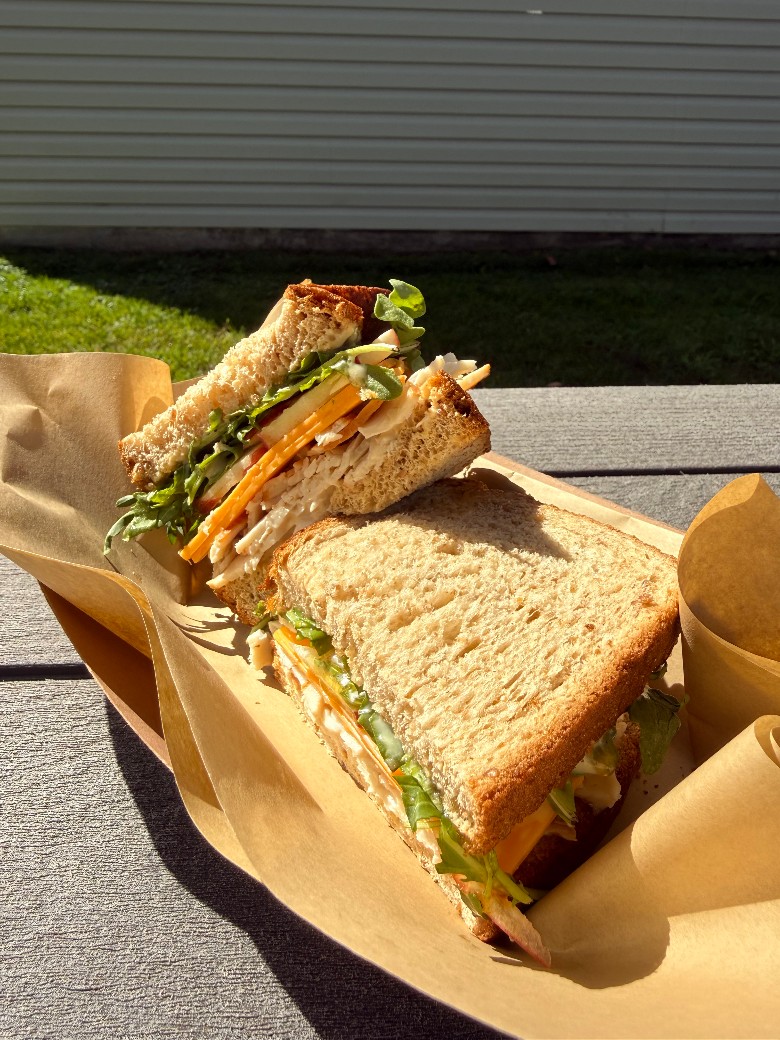 A wrapped deli-style sandwich from Harrisville Coffee Co., ready to go. sandwich split in half