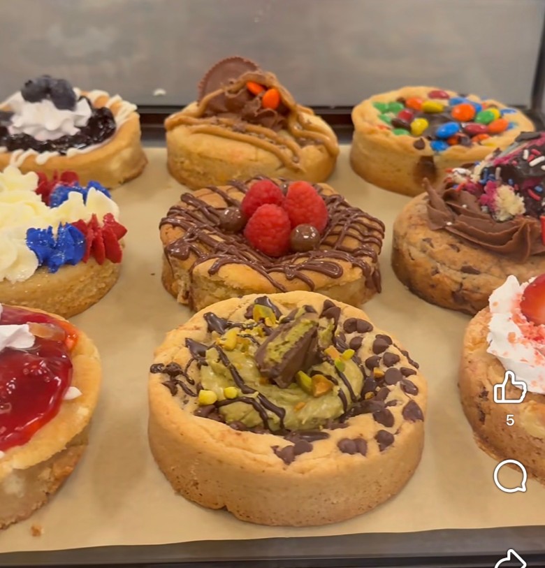 A close-up of assorted pastries and tarts topped with fresh berries and toppings. creative cookie cakes