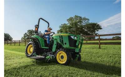 a large green tractor and lawn mower on grass