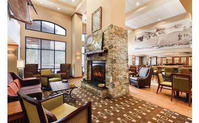 lobby filled with chairs, tables, and a fireplace
