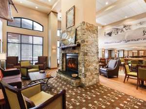 lobby filled with chairs, tables, and a fireplace