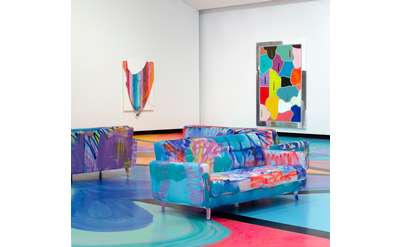 Colorful painted couches and floors in an art gallery with colorful paintings on the walls