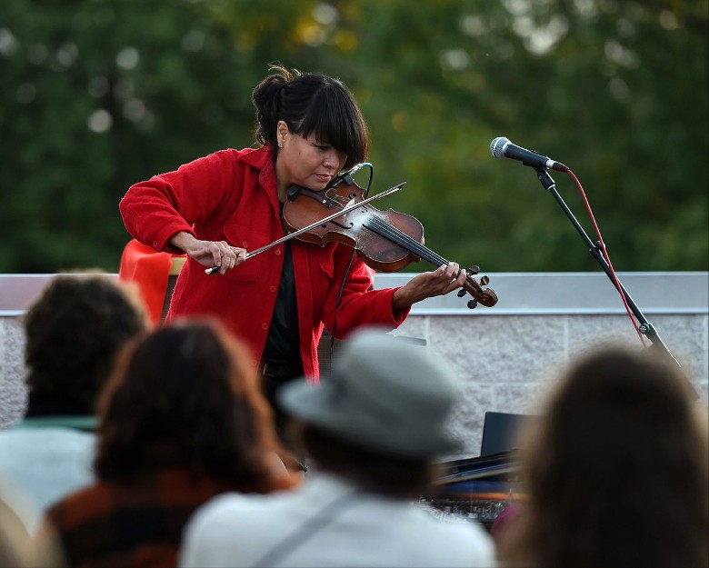 woman on violin on rooftop