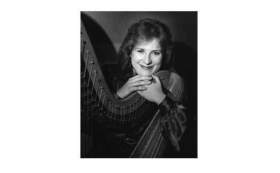 black and white photo of a woman posing with a harp