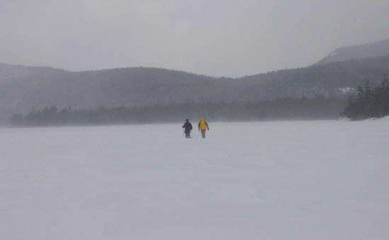 two people snowshoeing on the lake in winter