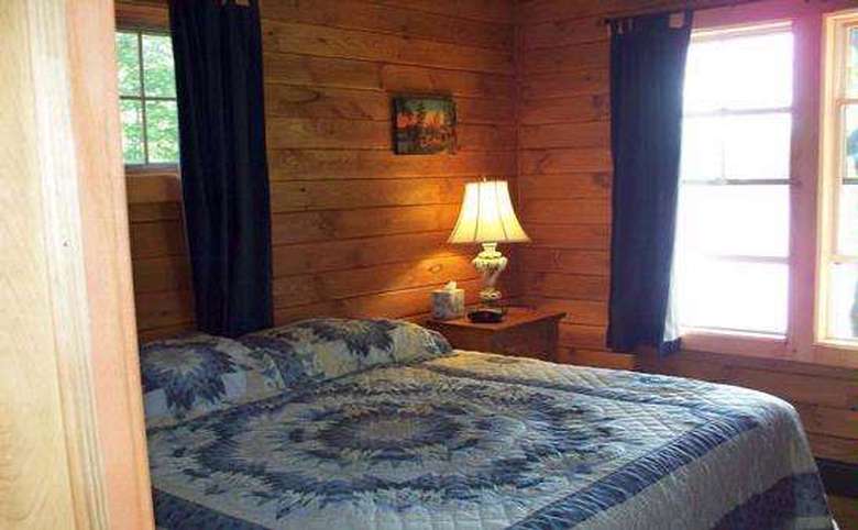 large bed in paneled bedroom with large windows