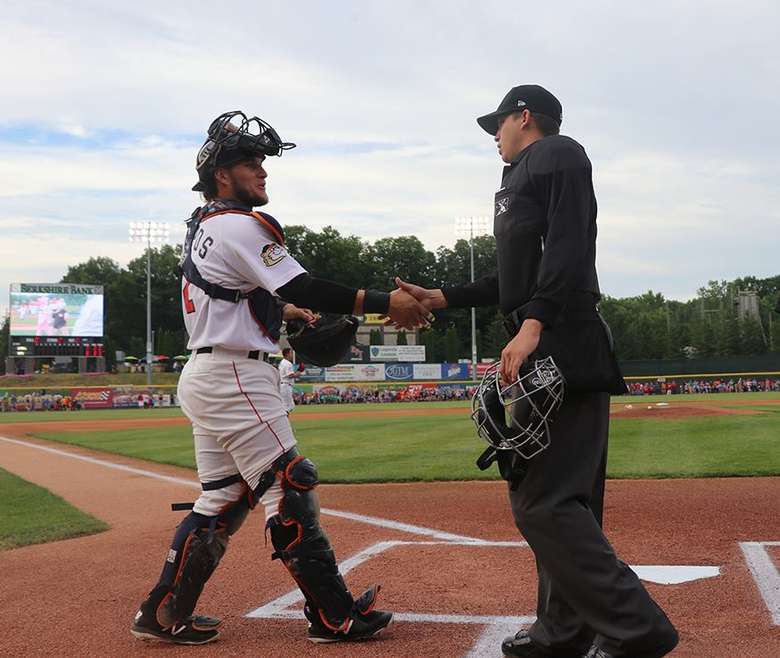 baseball player shaking hands with umpire
