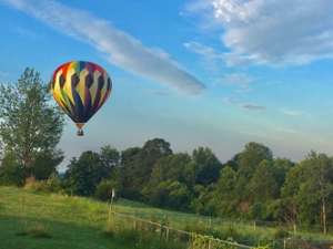a colorful hot air balloon in the sky above a field