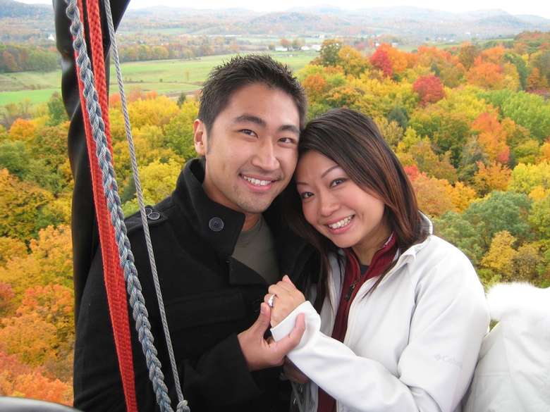 a man and woman holding hands in a hot air balloon