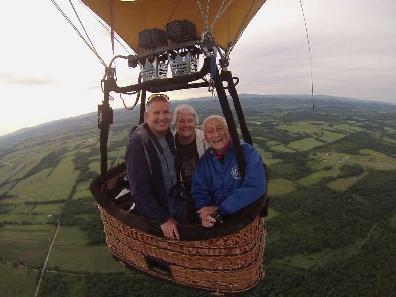 three people in a hot air balloon basket