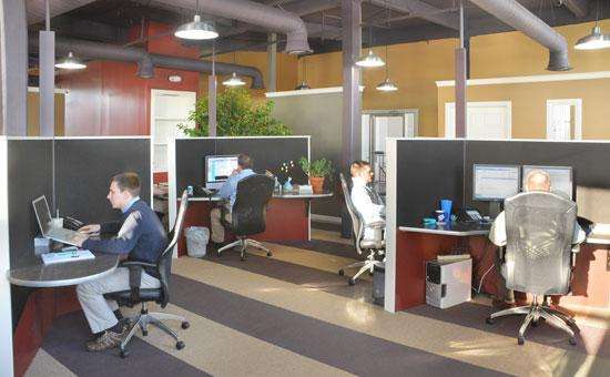 an office space with cubicles and people working at computers