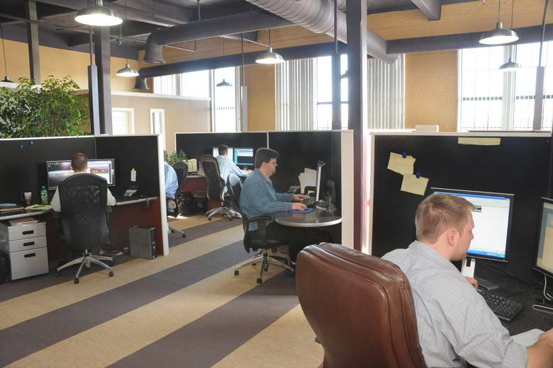 multiple office desk cubicles with people at them