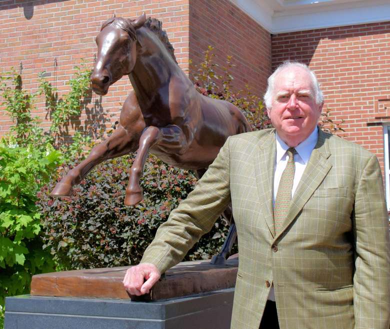 older man standing next to the secretariat statue outside the national museum of racing