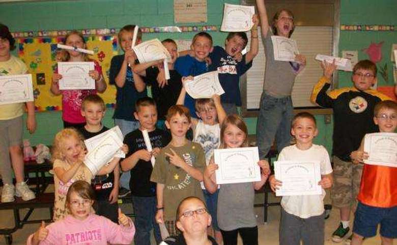 group of kids holding up certificates