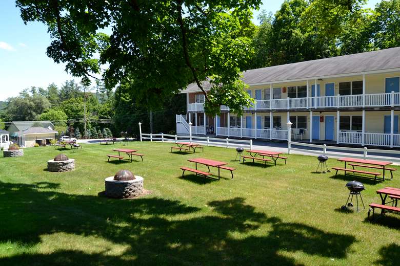 row of apartments or motels, picnic tables with grills on lawn