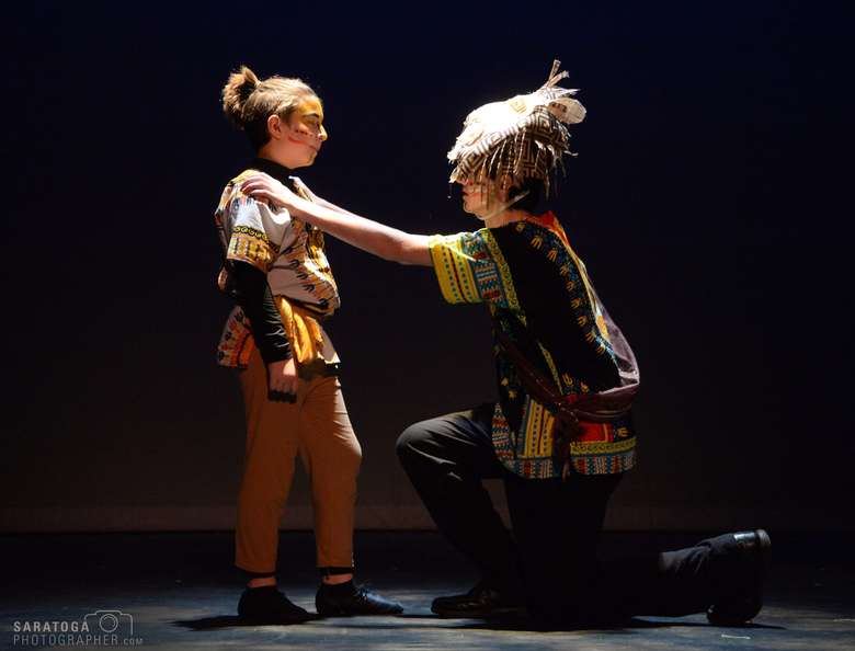 two actors performing on stage in tribal-style costumes
