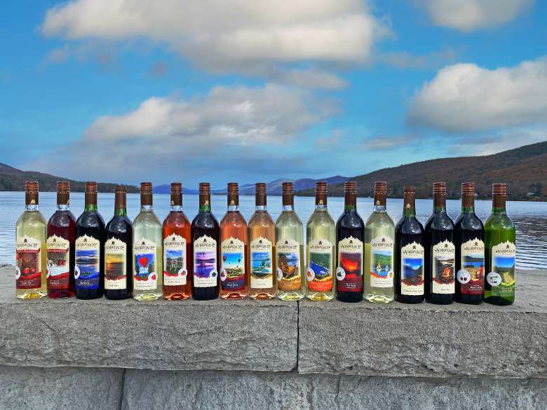 Wine bottles displayed on a stone wall by a lake