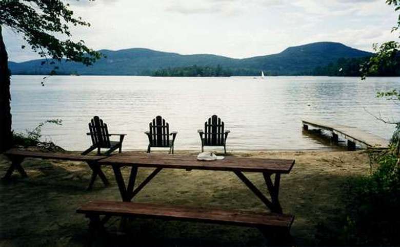 Two picnic tables, Adirondack chairs and a dock by the Lake