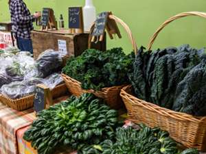 herbs and kale in bushels at a stand
