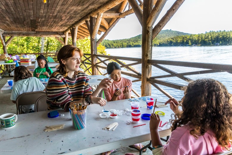 campers on the boathouse porch doing arts and crafts