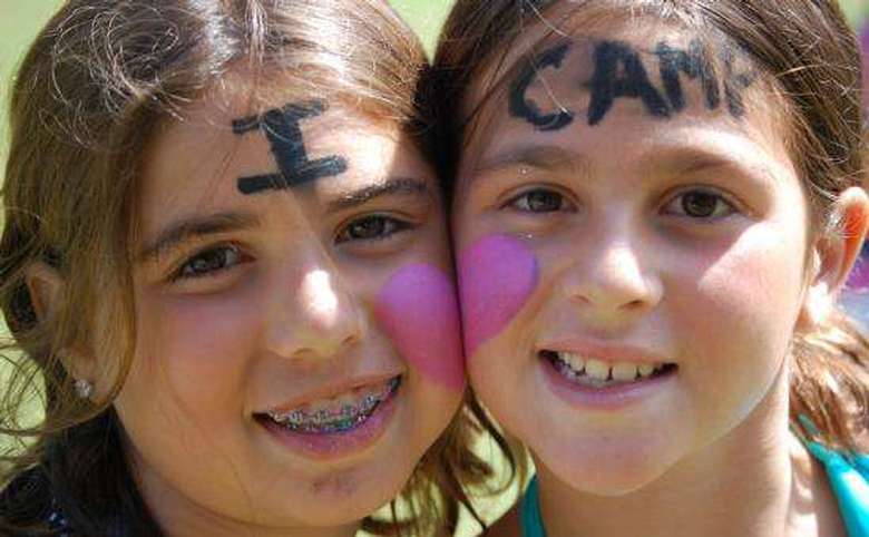 two girls with i heart camp painted on their faces