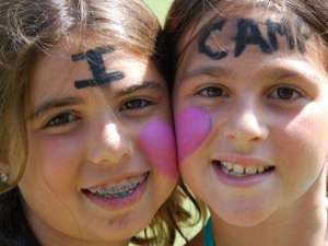two girls with i heart camp painted on their faces