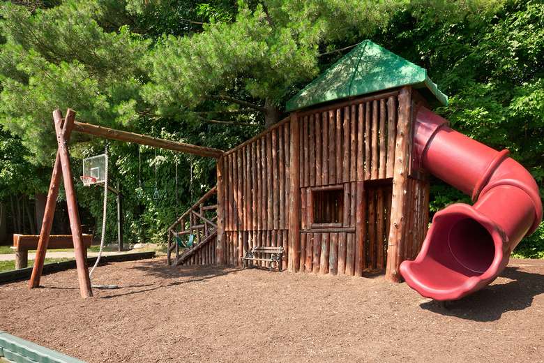 a playground area with swings and a red slide