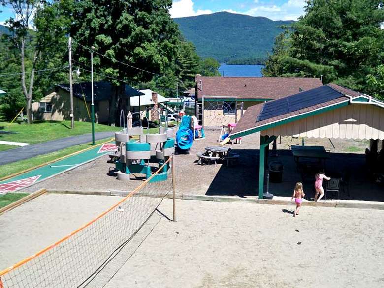 playground with a shuffle board court, volleyball court, and covered picnic pavilion