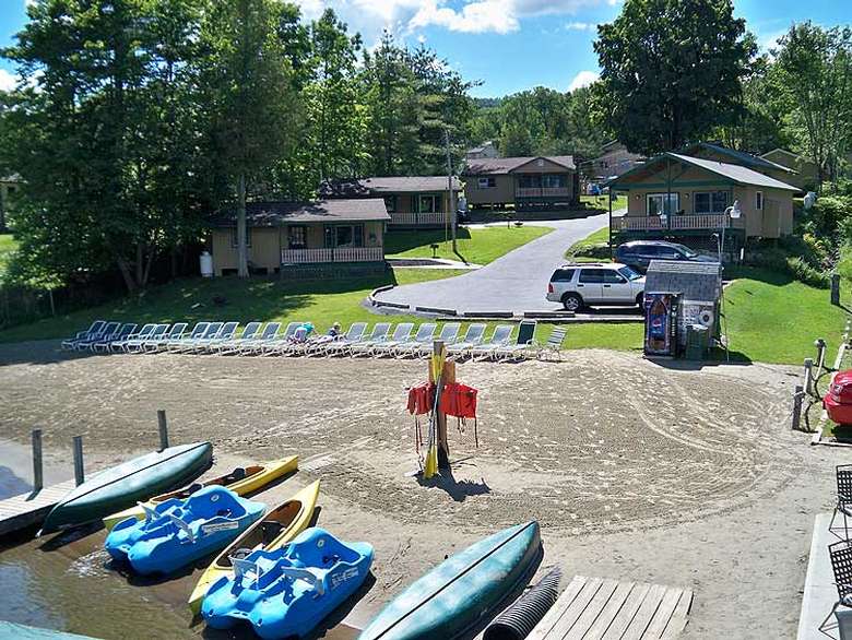 sandy beach with kayaks and paddleboats ready for launch